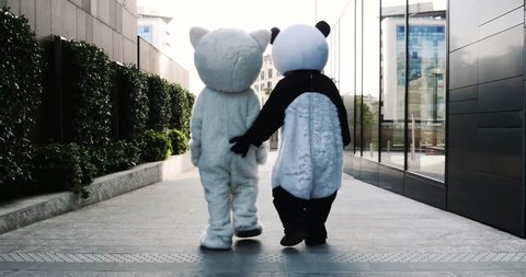 Two friends wearing animal costumes walking and having fun in the city