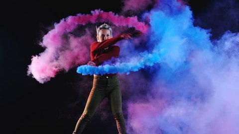 4K Girl is dancing a new style disco contemporary party solo dance with blue color smoke grenade in her hand. Slow motion (150fps) Shooted on Black Background (high quality)