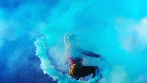 4K Hot Sexy Girl is dancing a new style disco contemporary party solo dance with blue color smoke grenade in her hand. Slow motion - Red Epic Dragon (150fps) Shooted on Black Background (high quality)