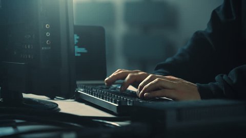 Computer hacker typing code on keyboard late night working. 