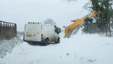 SHROPSHIRE, ENGLAND - MARCH 2ND 2018 - Van stuck in snow towed away by tractor 