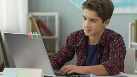 Teenager successfully doing practical work for programming lesson using laptop