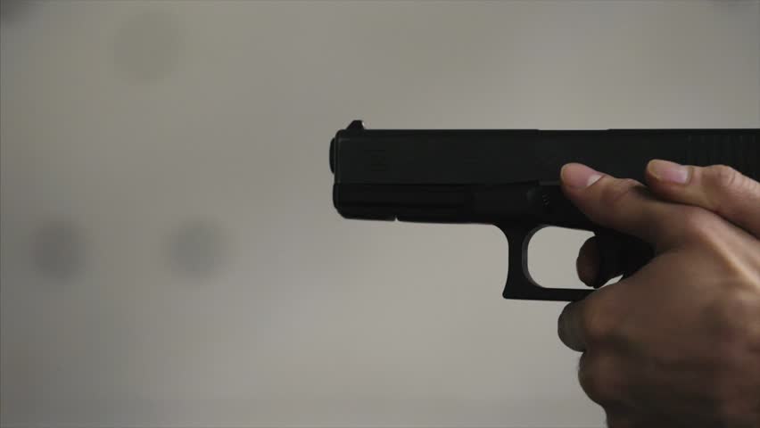 Gun is shot close-up. Pistol in hand close-up. Pistol being shot 1 times. Man shoots a black gun
