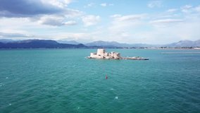 Aerial drone video from picturesque and famous venetian fortress and small islet of Bourtzi with views to iconic city of Nafplio former capital of Greece, Argolida, Peloponnese 