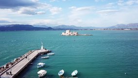 Aerial drone video from picturesque and famous venetian fortress and small islet of Bourtzi with views to iconic city of Nafplio former capital of Greece, Argolida, Peloponnese 