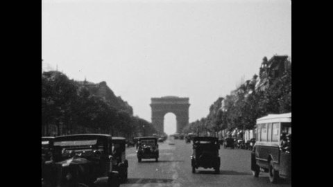 1920s: People sit at tables outside caf?. Cars driving to and away from Arc de Triomphe.
