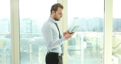Busy Business Man Working Using Computer Tablet While Walk in Office near Window