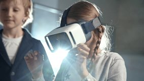 Primary school girl with two braids using virtual reality glasses as part of information technology lesson - Powered by Shutterstock - Get 15% off with code: PIKWIZARD15
