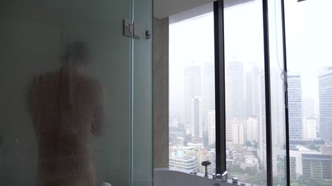 Young man in the bathroom. a handsome guy is wiped by a towel after a shower. 4k, slow motion