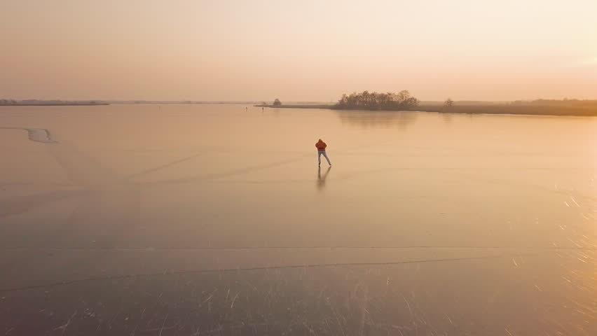 A man is skates on a natural frozen lake in the Netherlands. | Shutterstock HD Video #1008233068