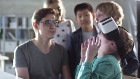 Teacher shows primary school children how to use virtual reality glasses during computer coding class, and they get excited - Powered by Shutterstock - Get 15% off with code: PIKWIZARD15