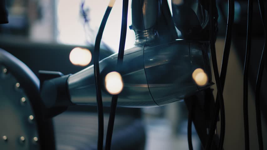 Closeup view on hair dryer surroundede with twinkle lights in beauty salon. Soft focus change