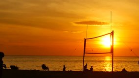 Slow Motion Video silhouette group of  person playing volleyball on the beach at sunset time with sunlight in sport and lifestyle concept