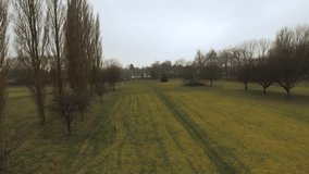 Aerial Drone Footage View: Rising flight over autumn golf course with trees,forests, fields and overcast soft light. Manchester, England Landscape.
