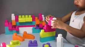 Little girl playing with colorful block.Real time footage of female asian kid playing with colorful mega block.Close up shot. 