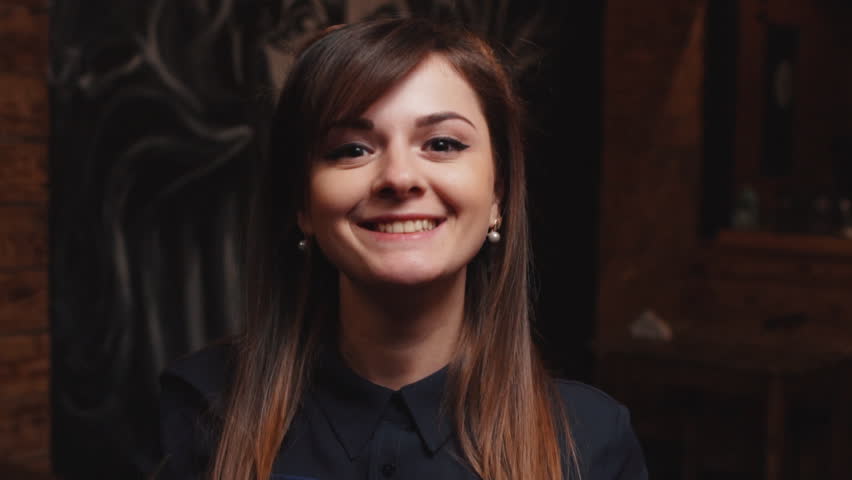 funny portrait of a young smiling woman hairdresser, slow motion