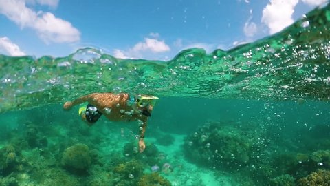 Young Male Snorkels The Great Barrier Reef in Slow Motion at 120fps, Above and Below, Beautiful Coral Reef and Turquoise Green Water, Tropical Paradise Vacation 