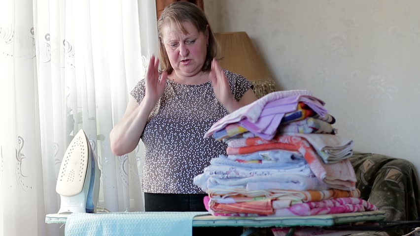 Tired elderly woman ironing clothes | Shutterstock HD Video #1008269002