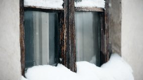 Detail clip with old wooden window during snowfall