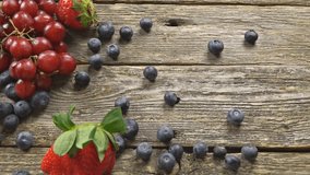 tasty summer fruits on a wooden table. Blueberries Grape Strawberries Blackberries SLOW MOTION hd video