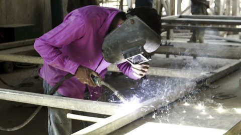 slow motion construction worker welding metal