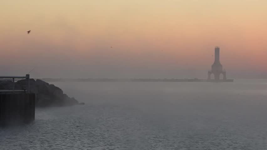 Foggy sunrise in the harbor featuring the lighthouse of Port Washington WI