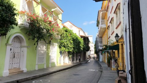 Empty street in Cartagena, Colombia with terraces, balconies, and flowers.