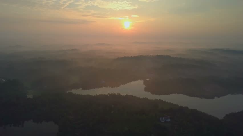 Aerial morning foggy calm lake and mountains after sunrise ceylon drone footage