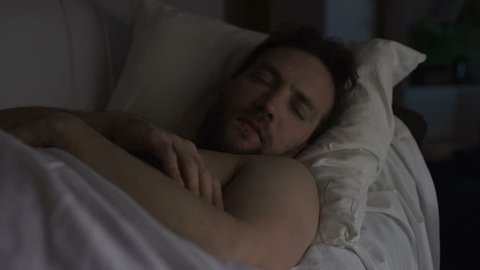 Drunken man sleeping on couch dreaming something bad, having hiccups in sleep