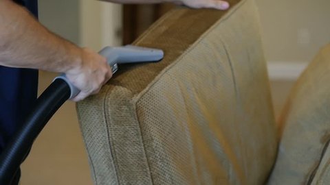 Wet vacuum cleans a green couch cushion in this slow motion clip.