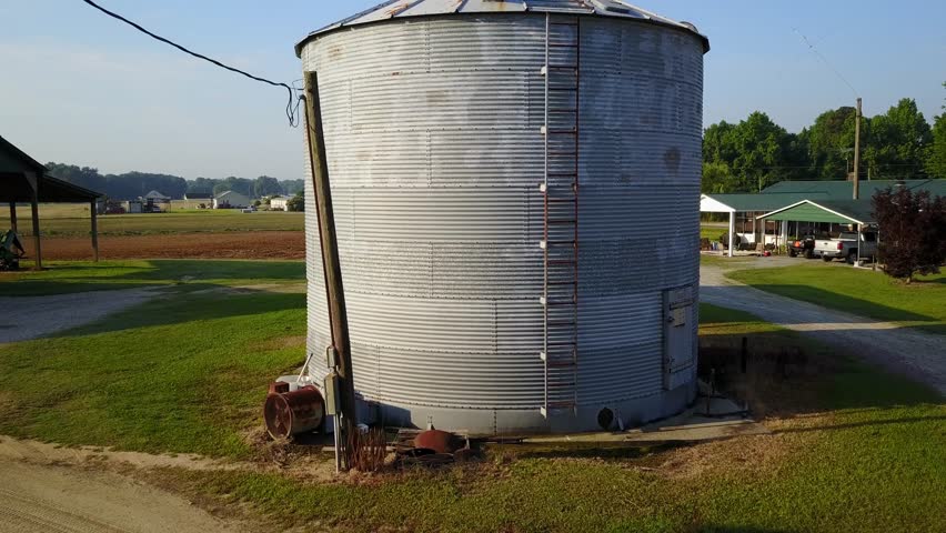 Aerial view of an old silo, then revealing farmland in eastern NC, US.