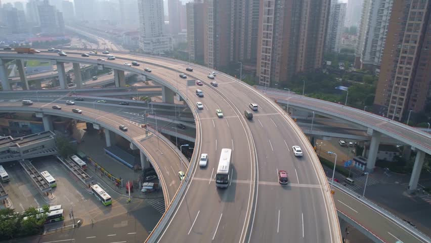 SHANGHAI, CHINA - MAY 5, 2017: Aerial view of Nanpu bridge highway junction. Cars moving by spiral, fog, sunny day.