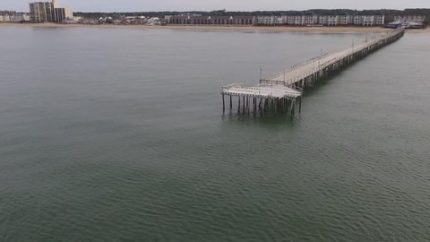 Drone Hover Shot of the End of the Pier in the Ocean and the Beach