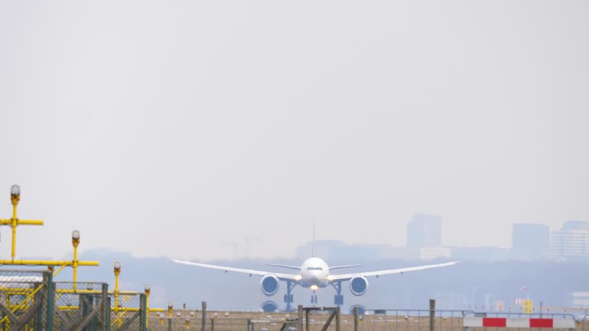 4K Big passenger airplane taking off from the runway with city skyline in the background.  Royalty-Free Stock Footage #1008328720