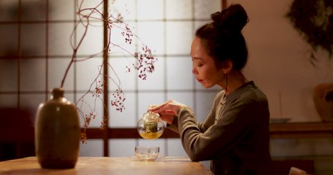Japanese Female pouring green tea in traditional house, Kyoto, Japan