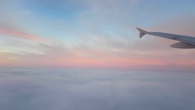 A breathtaking view from a jet airplane window flying over picturesque and sparkling pink and whiteclouds on a sunny day in summer. - Powered by Shutterstock - Get 15% off with code: PIKWIZARD15