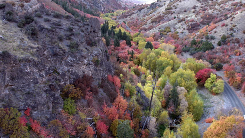 Flying past rocky hillside over colorful Fall foliage in Santaquin Canyon Utah, 1 of 2.