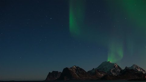 Northern lights (aurora borealis) over the mountains in Lofoten islands, Norway. Night winter landscape with polar lights and beautiful starry sky. Time-lapse video