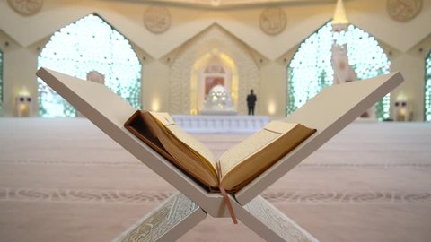 A Muslim man reads a koran or quran in an Islamic mosque