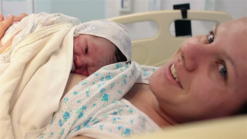 a newborn baby lies on the breast of a happy mother in the hospital. The first minutes of life. childbed. Royalty-Free Stock Footage #1008350716