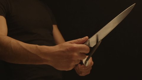 Man sharpens a knife on a sharpener