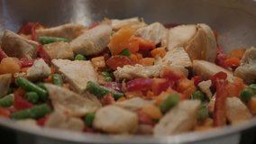 Tasty lunch in frying pan slow motion 1920X1080 HD video - Mixing of vegetables with poultry meat close-up 1080p FullHD footage