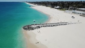 Aerial video of a Blue Baywatch House on a pier surrounded by a turquoise waters of Indian Ocean- South City Beach, Western Australia.