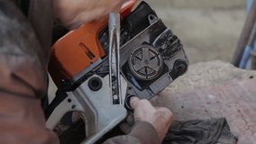 grandpa repairs a chainsaw