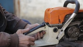 grandpa repairs a chainsaw