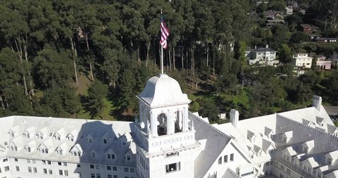 Shot revolving around the main tower of a building on a sunny day in Berkeley, CA with an American Flag waving in the wind