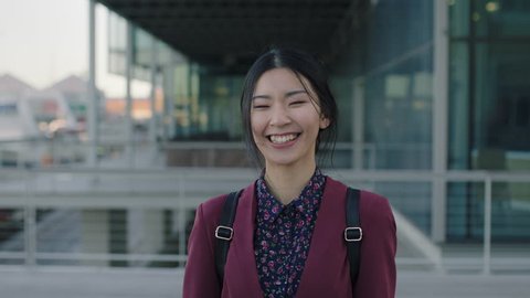 portrait of young asian woman student laughing happy standing campus university learning