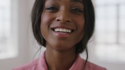 close up portrait of young pretty african american woman laughing happy enjoying positive lifestyle move in new apartment wearing pink blouse
