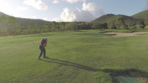 A man playing golf on a lush green golf course. 