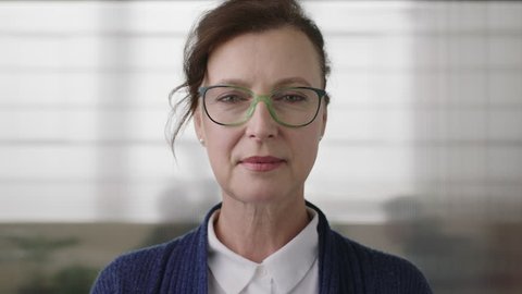 portrait of successful senior business woman boss looking serious confident at camera wearing glasses in office workspace background close up